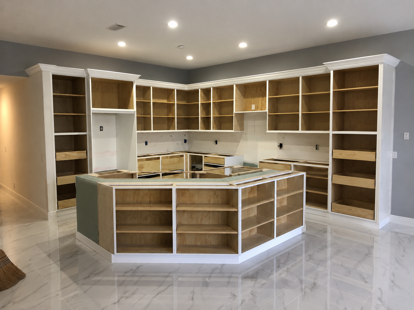 Same kitchen during installation — unfinished cabinet boxes and exposed framing
